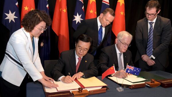 Australian Prime Minister Tony Abbott (C) watches as China's Minister of Commerce Gao Hucheng (2nd L) and Australian Minister for Trade Andrew Robb (2nd R) sign a trade agreement during an official signing ceremony in Canberra June 17, 2015 - Sputnik International