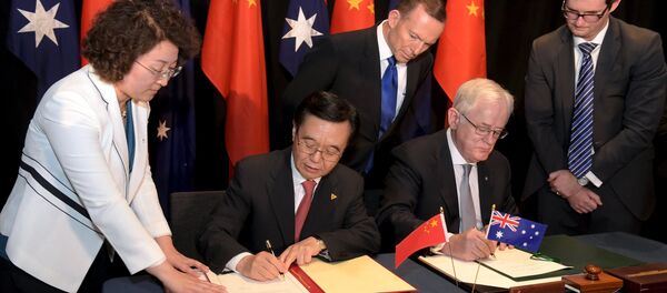 Australian Prime Minister Tony Abbott (C) watches as China's Minister of Commerce Gao Hucheng (2nd L) and Australian Minister for Trade Andrew Robb (2nd R) sign a trade agreement during an official signing ceremony in Canberra June 17, 2015 Australian Prime Minister Tony Abbott (C) watches as China's Minister of Commerce Gao Hucheng (2nd L) and Australian Minister for Trade Andrew Robb (2nd R) sign a trade agreement during an official signing ceremony in Canberra June 17, 2015 - Sputnik International