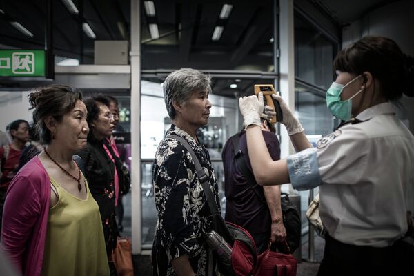 Passengers get their temperature checked as part of preventive measures against the spread of Middle East Respiratory Syndrome (MERS) at the Hong Kong international airport on June 5, 2015 Passengers get their temperature checked as part of preventive measures against the spread of Middle East Respiratory Syndrome (MERS) at the Hong Kong international airport on June 5, 2015 - Sputnik International