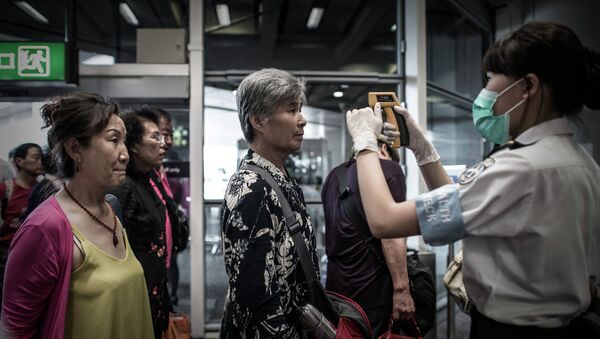 Passengers get their temperature checked as part of preventive measures against the spread of Middle East Respiratory Syndrome (MERS) at the Hong Kong international airport on June 5, 2015 - Sputnik International
