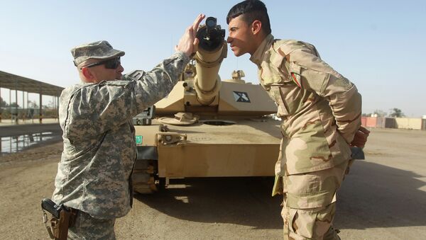 American military trainer shows an Iraqi soldier how to use a collimator to calibrate the gun barrel of an Abrams tank during a training session at the Taji base complex, which hosts Iraqi and US troops - Sputnik International