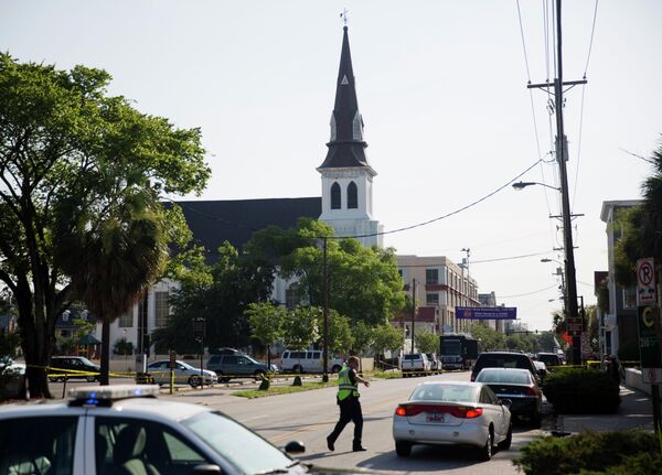 The steeple of Emanuel AME Church rises above the street as a police officer tells a car to move as the area is closed off following Wednesday's shooting, Thursday, June 18, 2015 in Charleston, S.C. - Sputnik International