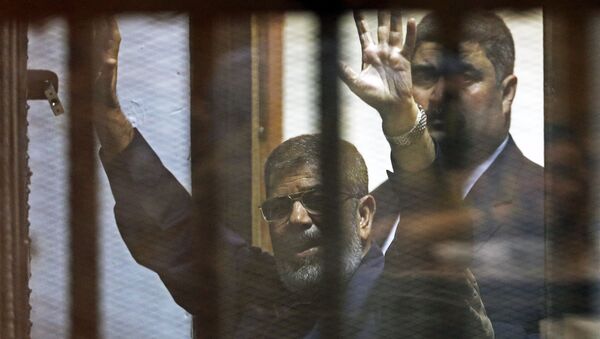 Deposed Egyptian President Mohamed Mursi greets his lawyers and people from behind bars after his verdict at a court on the outskirts of Cairo, Egypt - Sputnik International