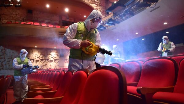 South Korean workers wearing protective gear fumigate a theater at the Sejong Culture Center in Seoul - Sputnik International