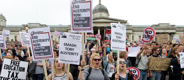Protestors hold placards as they listen to speeches during an anti-austerity demonstration in London - Sputnik International