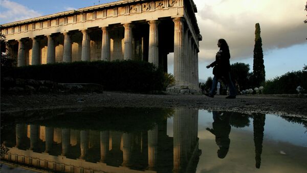 A tourist is reflected in a rain puddle as she walks past the 2,400-year-old temple of Ifestos in the ancient Agora of Athens, Greece - Sputnik International