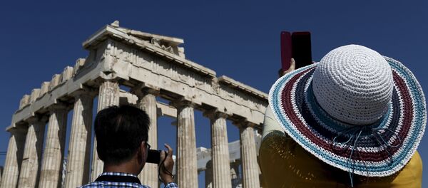Visitors take pictures in front of the Parthenon temple atop the Acropolis hill in Athens Visitors take pictures in front of the Parthenon temple atop the Acropolis hill in Athens - Sputnik International