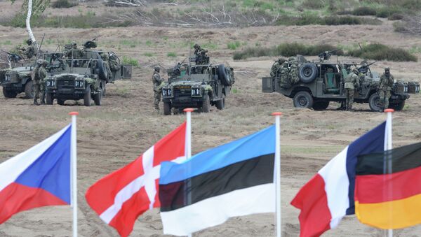 Flags wave in front of soldiers who take positions with their army vehicles during the NATO Noble Jump exercise on a training range near Swietoszow Zagan, Poland, Thursday, June 18, 2015 - Sputnik International