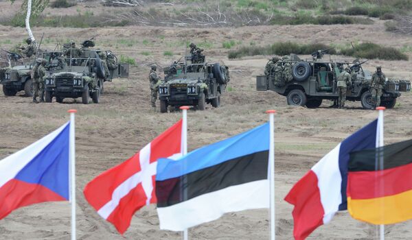 Flags wave in front of soldiers who take positions with their army vehicles during the NATO Noble Jump exercise on a training range near Swietoszow Zagan, Poland, Thursday, June 18, 2015 Flags wave in front of soldiers who take positions with their army vehicles during the NATO Noble Jump exercise on a training range near Swietoszow Zagan, Poland, Thursday, June 18, 2015 - Sputnik International