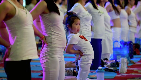 A child performs yoga at a hotel banquet hall to mark the International Yoga Day, in Changping District, on the outskirts of Beijing, China, Sunday, June 21, 2015 - Sputnik International