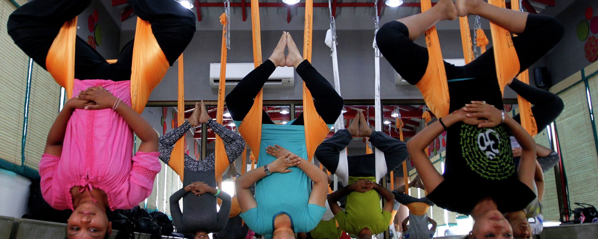 In this Thursday, June 18, 2015, photo, Indians perform anti gravity aerial yoga in Ahmadabad, India - Sputnik International, 1920, 21.06.2021