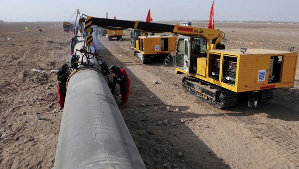 In this photo released by China's Xinhua News Agency, workers weld pipes at the construction site of the second project of west-to-east natural gas transmission pipeline in Fengle Town of Wuwei City, northwest China's Gansu Province, on Monday, March 10, 2008 - Sputnik International