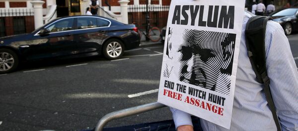 A supporter of Wikileaks founder Julian Assange holds a placard with his mouth during a gathering outside the Ecuador embassy in London, Britain June 19, 2015 A supporter of Wikileaks founder Julian Assange holds a placard with his mouth during a gathering outside the Ecuador embassy in London, Britain June 19, 2015 - Sputnik International