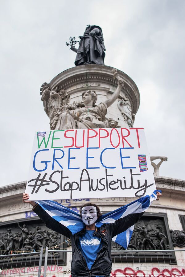 A man holds up a sign reading We support Greece #StopAusterity at the Republique Square during a demonstration against austerity in support of the Greek population in Paris, France, Saturday, June 20, 2015. - Sputnik International