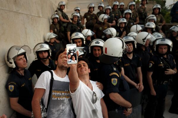 Pro-Euro demonstrators take a photograph in front of riot police outside the Greek Parliament during a rally in Athens, Monday, June 22, 2015. Thousands of people gathered to show support for the country's future in the Eurozone and the European Union. - Sputnik International