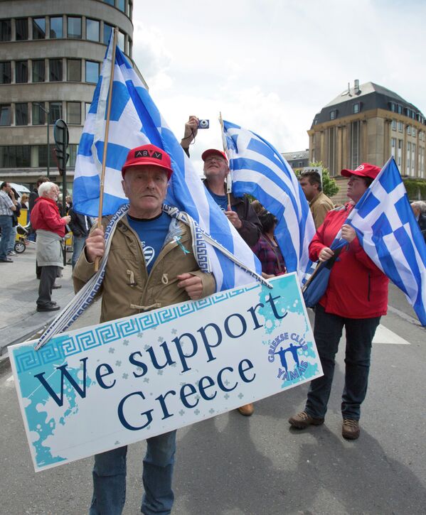 Demonstrators hold flags and banners during a protest march in solidarity with Greece in the center of Brussels on Sunday, June 21, 2015. - Sputnik International