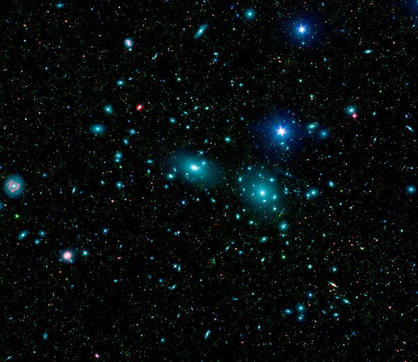 This false-color mosaic of the central region of the Coma cluster combines infrared and visible-light images to reveal thousands of faint objects (green) This false-color mosaic of the central region of the Coma cluster combines infrared and visible-light images to reveal thousands of faint objects (green) - Sputnik International
