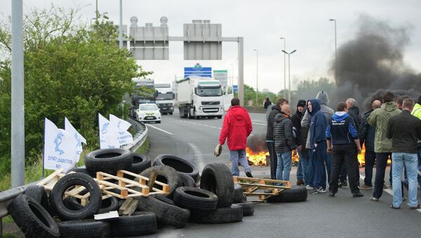 Striking ferry workers burn tyres as they block a ramp leading into the Eurotunnel before being dispersed by riot police in Calais, northern France, Tuesday, June 23, 2015 - Sputnik International