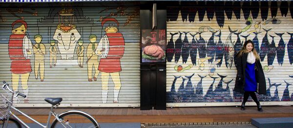 A woman stands in front of a closed shop in the outer part of the Tsukiji fish market, the Jogai Shijo, in Tokyo A woman stands in front of a closed shop in the outer part of the Tsukiji fish market, the Jogai Shijo, in Tokyo - Sputnik International