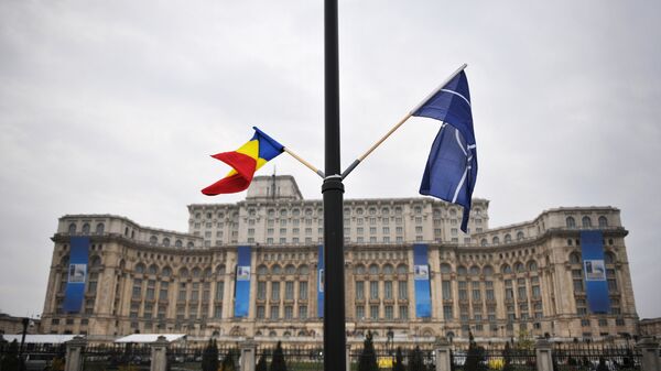 File photo of the Romanian and the NATO flag flutter in the wind in front of the Parliament Palace, the second largest building in the world after the Pentagon, in Bucharest on April 1, 2008 on the eve of the start of the NATO summit taking place form April 2 to 4 - Sputnik International