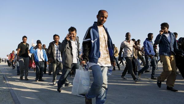 Migrants walk after disembarking from the Spanish Civil Guard's ship Rio Segura, in the Sicilian harbour of Augusta, Italy, June 23, 2015 - Sputnik International