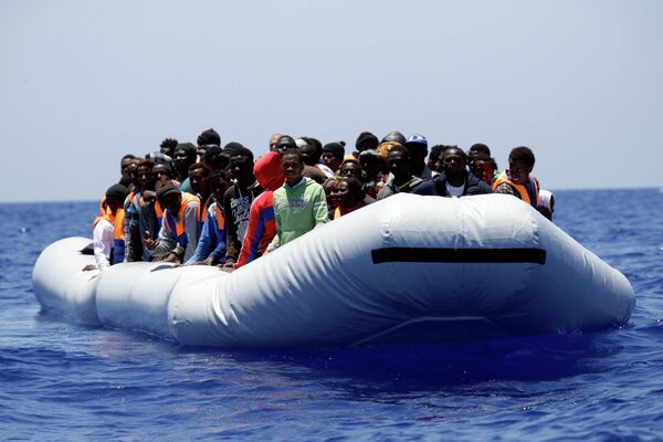 A rubber boat loaded of migrants is seen during a search and rescue mission in the Mediterranean Sea off the Libyan coasts, Italy, Tuesday, June 23, 2015 A rubber boat loaded of migrants is seen during a search and rescue mission in the Mediterranean Sea off the Libyan coasts, Italy, Tuesday, June 23, 2015 - Sputnik International