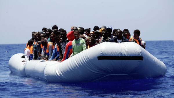 A rubber boat loaded of migrants is seen during a search and rescue mission in the Mediterranean Sea off the Libyan coasts, Italy, Tuesday, June 23, 2015 - Sputnik International