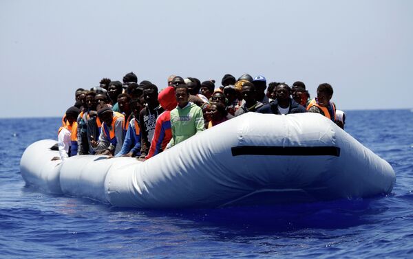 A rubber boat loaded of migrants is seen during a search and rescue mission in the mediterranean sea off the Libyan coasts, Italy, Tuesday, June 23, 2015 - Sputnik International