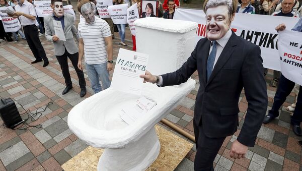 An activist wearing a mask depicting Ukrainian President Petro Poroshenko (R) places mock criminal files in a fake toilet during a performance to protest against what the activists said was corruption in the government, in front of the parliament building in Kiev, Ukraine, June 17, 2015 - Sputnik International