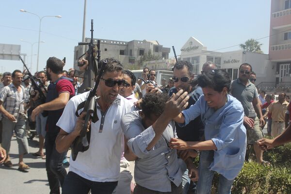Police officers control the crowd (rear) while surrounding a man (front C) suspected to be involved in opening fire on a beachside hotel in Sousse, Tunisia, as a woman reacts(R), June 26, 2015 - Sputnik International