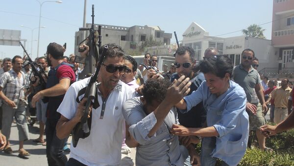 Police officers control the crowd (rear) while surrounding a man (front C) suspected to be involved in opening fire on a beachside hotel in Sousse, Tunisia, as a woman reacts(R), June 26, 2015 - Sputnik International