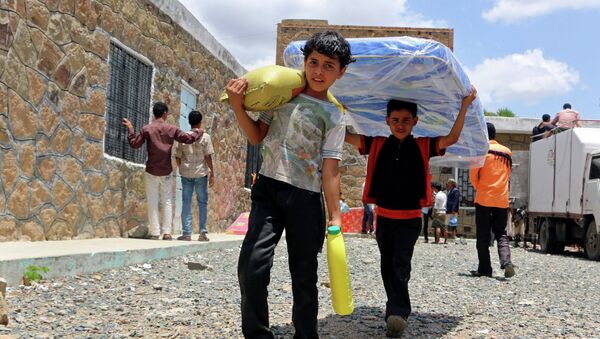 Boys carry relief supplies to their families who fled fighting in the southern city of Aden, during a food distribution effort by Yemeni volunteers, in Taiz, Yemen. - Sputnik International