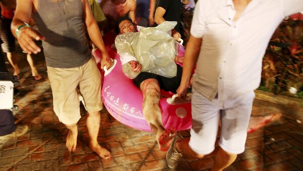 People carry an injured victim from an accidental explosion during a music concert at the Formosa Water Park in New Taipei City, Taiwan, June 27, 2015 - Sputnik International