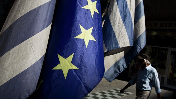 A man walks past a European and Greek flags in central Athens, on Tuesday, June 30, 2015. - Sputnik International