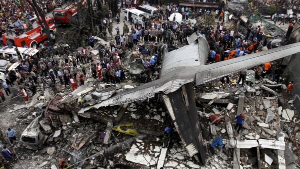 Security forces and rescue teams examine the wreckage of an Indonesian military C-130 Hercules transport plane after it crashed into a residential area in the North Sumatra city of Medan, Indonesia - Sputnik International