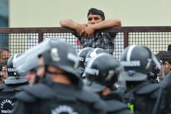 Policemen stand at the entrance of the Debrecen refugee camp in Debrecen, 230 kms from Budapest, Hungary, Monday, June 29, 2015. Police say they used tear gas to stop hundreds of refugees involved in a fight at a refugee camp in this eastern Hungarian city. Policemen stand at the entrance of the Debrecen refugee camp in Debrecen, 230 kms from Budapest, Hungary, Monday, June 29, 2015. Police say they used tear gas to stop hundreds of refugees involved in a fight at a refugee camp in this eastern Hungarian city. - Sputnik International