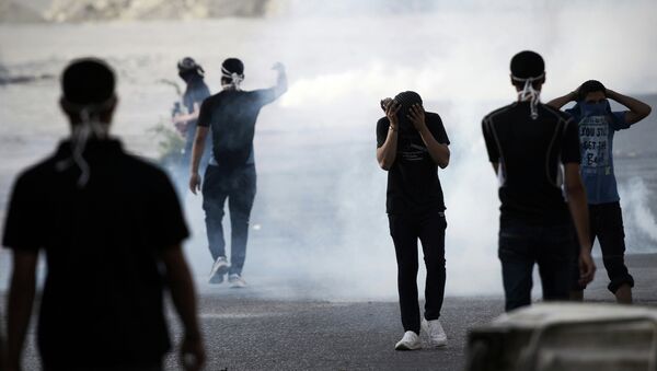 Bahraini protesters stand amid smoke of tear gas fired by riot police - Sputnik International