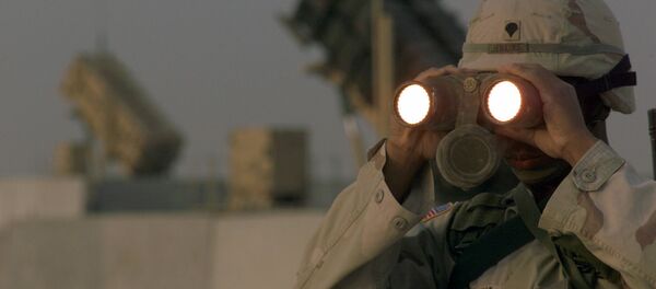 US soldier uses a pair of binoculars to scans the landscape around his Patriot Missiles based at Al Udeid AB, Qatar - Sputnik International