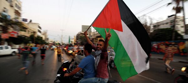 Palestinians wave the national flag as they gather is the streets of Gaza City on August 26, 2014 Palestinians wave the national flag as they gather is the streets of Gaza City on August 26, 2014 - Sputnik International