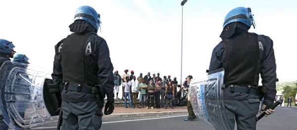 Italian policemen stand in front of migrants at the Franco-Italian border near Menton, southeastern France, Tuesday, June 16, 2015 Italian policemen stand in front of migrants at the Franco-Italian border near Menton, southeastern France, Tuesday, June 16, 2015 - Sputnik International