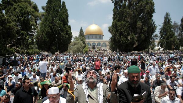 Palestinian Muslim worshipers pray outside the Dome of the Rock at the Al-Aqsa Mosque compound in Jerusalem during the second Friday prayer of the holy month of Ramadan, on June 26, 2015 - Sputnik International