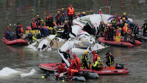 Emergency personnel retrieve the body of a passenger of a commercial plane after it crashed in the water in Taipei, Taiwan, Wednesday, Feb. 4, 2015 - Sputnik International
