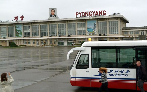 This photo taken on September 21, 2010 shows a foreign visitor (L) taking pictures of Pyongyang airport with a portrait of late North Korean leader Kim Il-Sung on the roof in Pyongyang This photo taken on September 21, 2010 shows a foreign visitor (L) taking pictures of Pyongyang airport with a portrait of late North Korean leader Kim Il-Sung on the roof in Pyongyang - Sputnik International