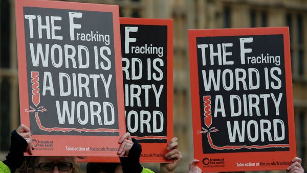 Demonstrators hold up placards as they take part in an anti-fracking protest outside the Palace of Westminster in London. - Sputnik International