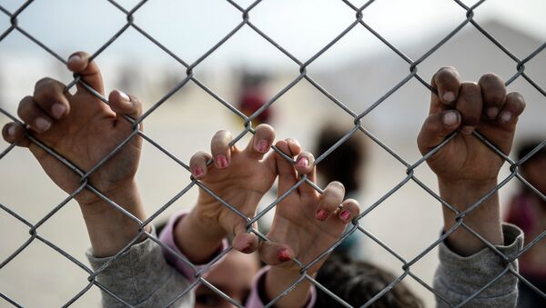 Hands of Syrian Kurdish children are seen holding a fence in a UNHCR (United Nations Refugee Agency) refugee camp on February 2, 2015, at Suruc, in Sanliurfa - Sputnik International