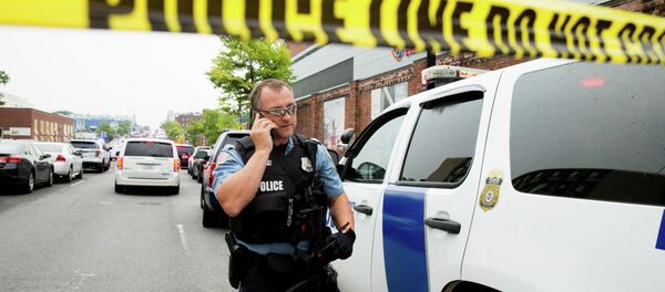 A police officer speaks on his phone as a large police presence gathers along M St. in Southeast Washington, Thursday, July 2, 2015, after an official said shots have been reported in a building on the Washington Navy Yard campus - Sputnik International