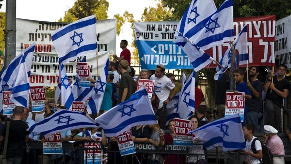 Right-wing activists hold Israeli national flags during a demonstration calling on the Israeli government to take action against recent violence in Jerusalem July 1, 2015 - Sputnik International