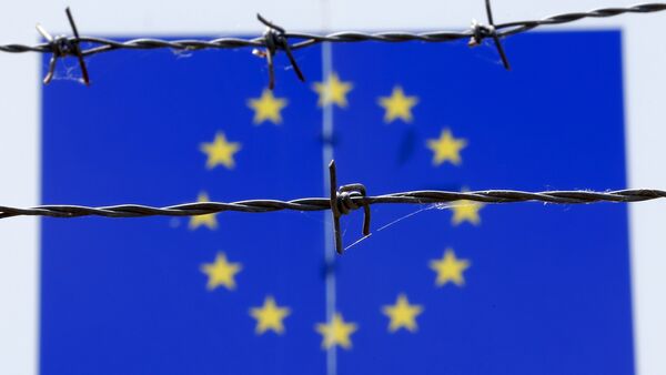 A barbed wire is seen in front of a European Union flag - Sputnik International
