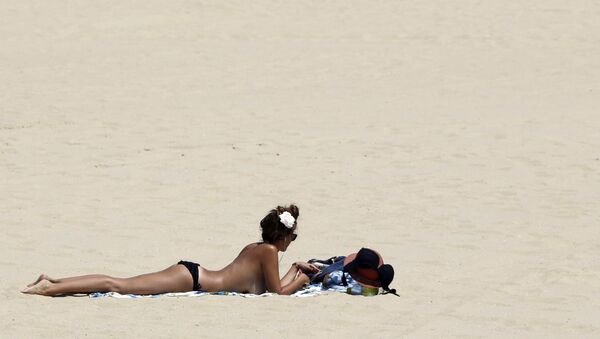A woman sunbathes on a beach along the Bassin d'Arcachon Sea during a warm and sunny day in Arcachon near Bordeaux, southwestern France, July 1, 2015. - Sputnik International