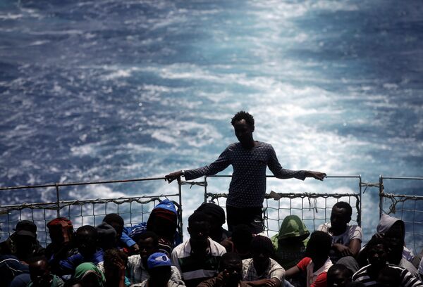 Migrants sit on the deck of the Belgian Navy vessel Godetia after they were saved at sea during a search and rescue mission in the Mediterranean Sea off the Libyan coasts, Wednesday, June 24, 2015. Migrants sit on the deck of the Belgian Navy vessel Godetia after they were saved at sea during a search and rescue mission in the Mediterranean Sea off the Libyan coasts, Wednesday, June 24, 2015. - Sputnik International